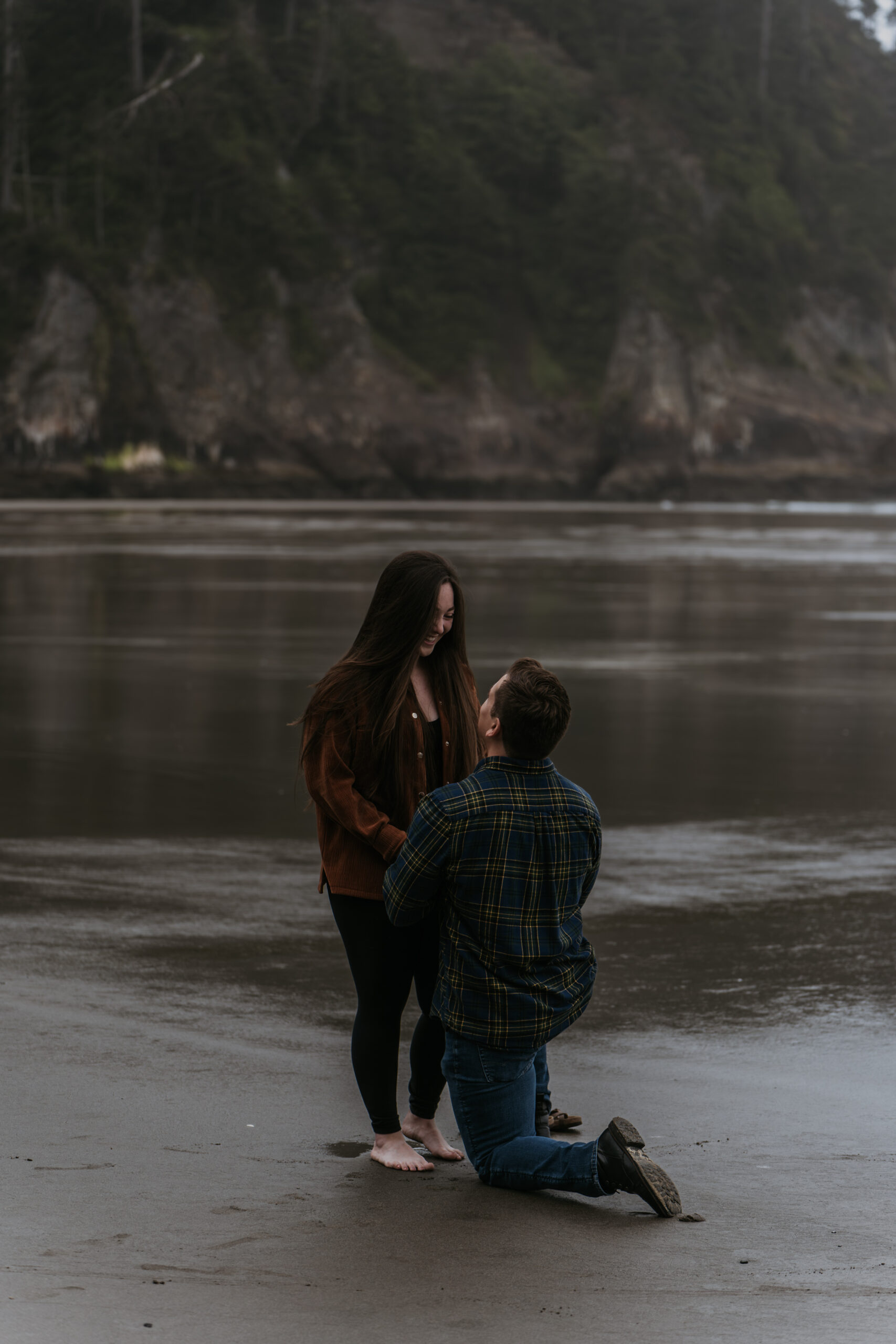 man proposal to women on beach on the sand with moody weather