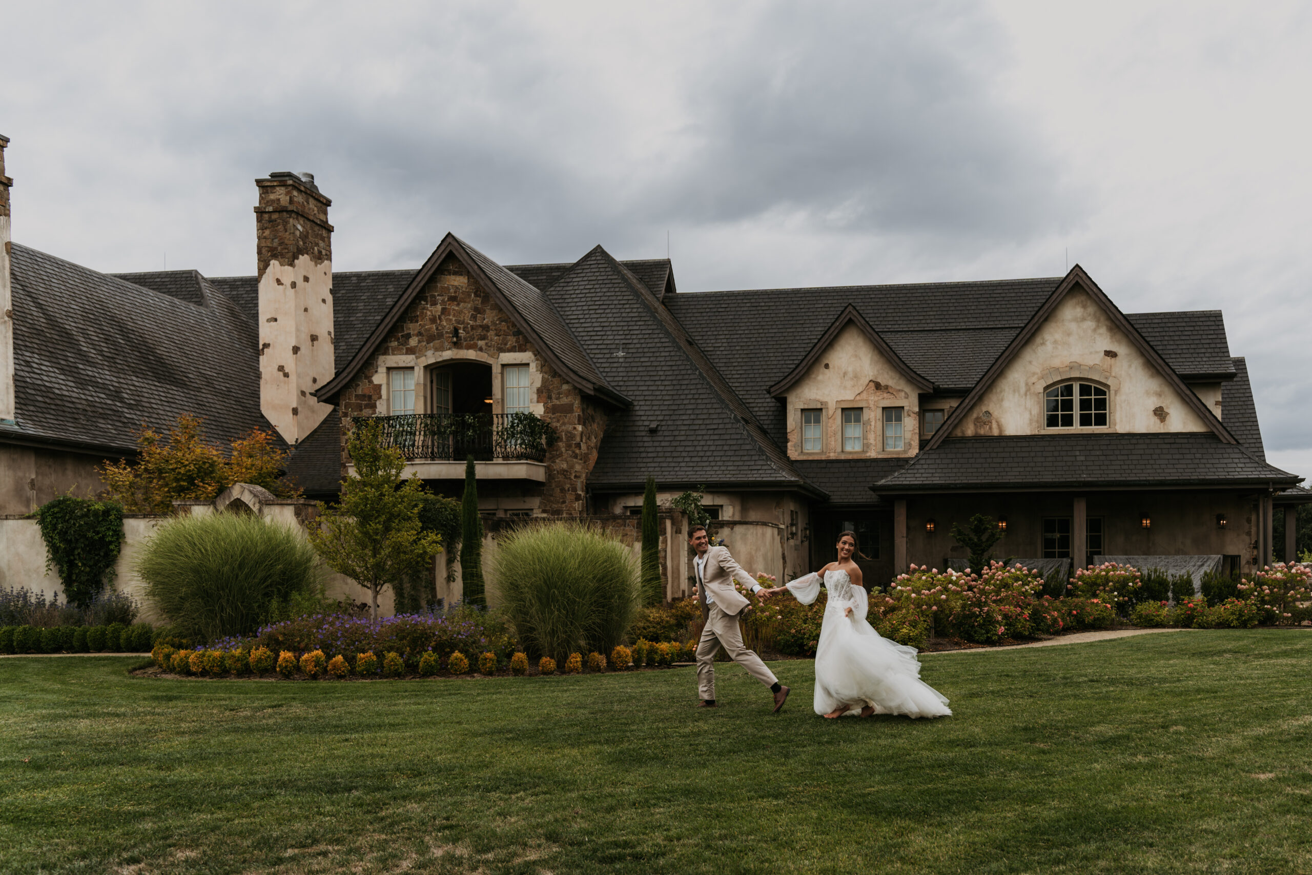 bride and groom running around in front of European castle venue