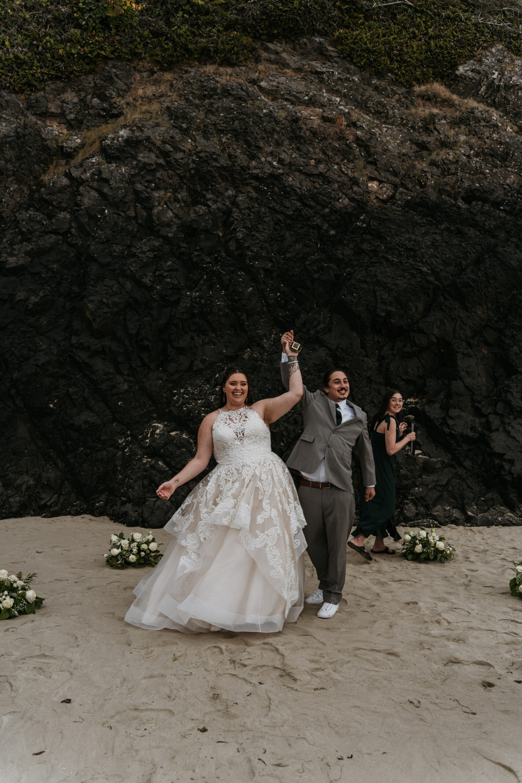 bride and groom cheering at ceremony they got eloped on beach