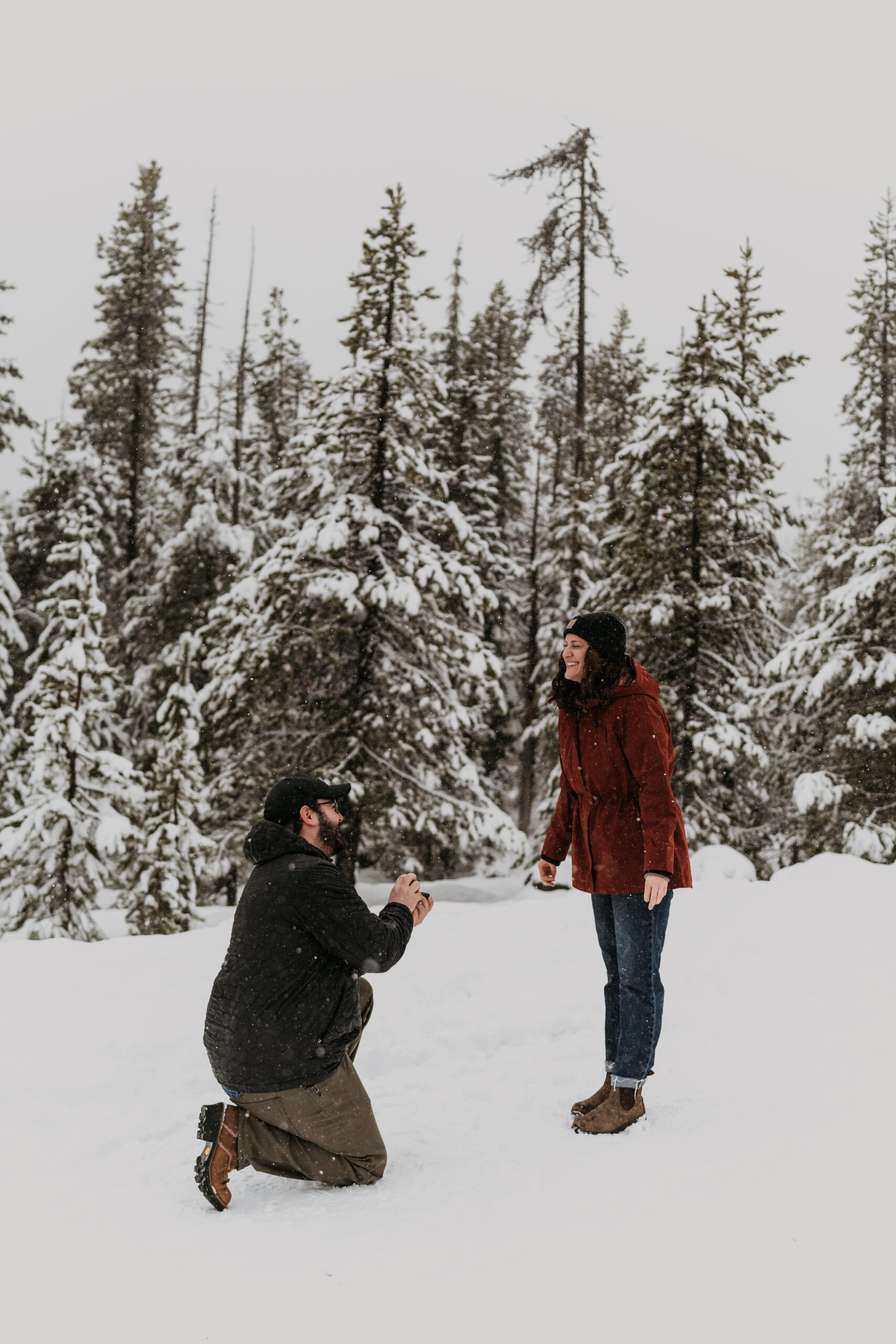 man proposing to women in snowy forest