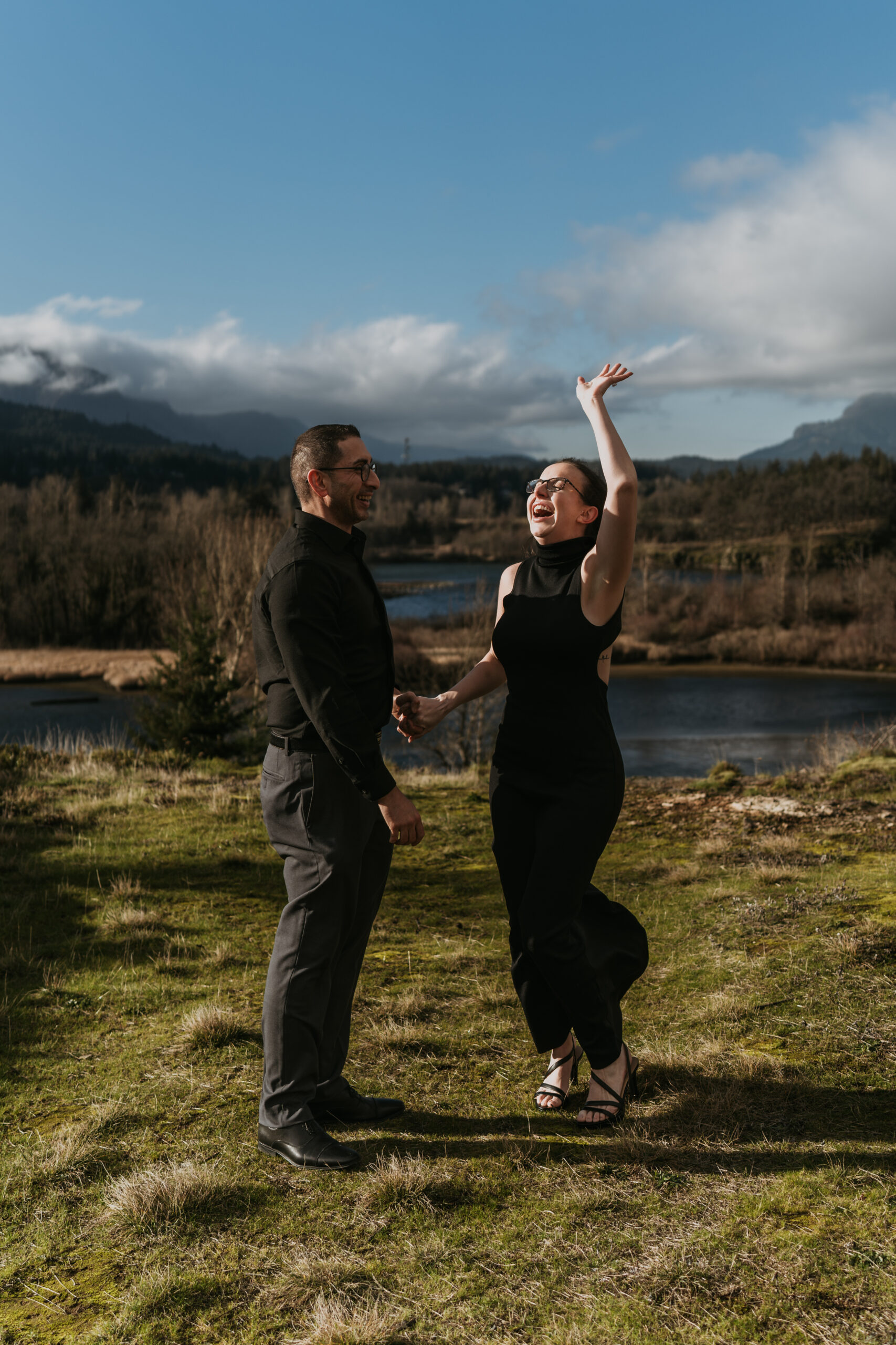 women jumping for joy with man after just getting proposed to with beautiful view of mountains in background