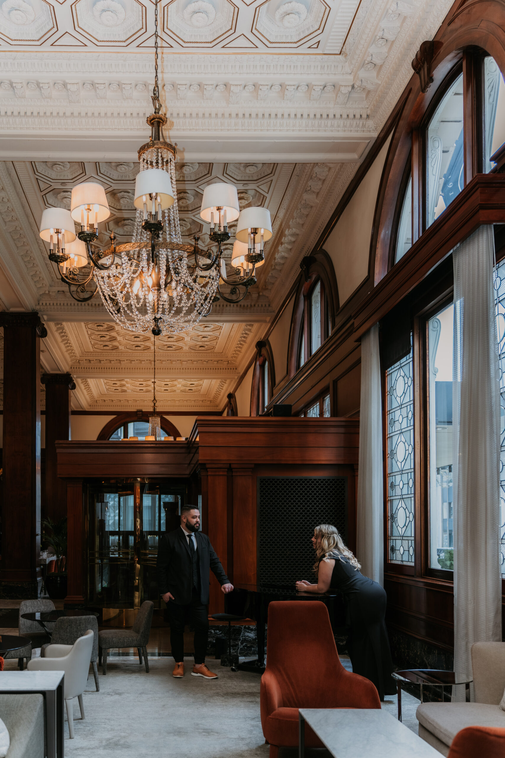 couple leaning on piano in luxury hotel