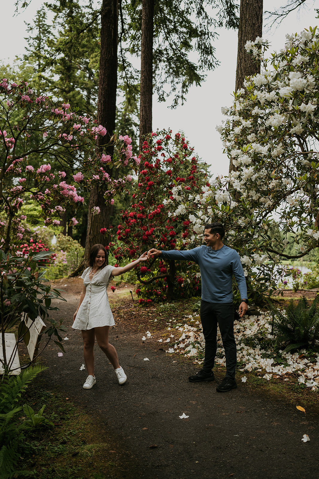man spinning women in garden full of flowers and trees